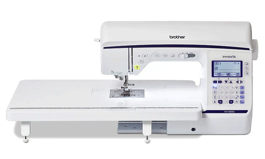 Frontal view of the Brother Innov-is NV1800Q sewing and quilting machine, complete with its wide table attachment, showcasing its sleek design and advanced control panel.