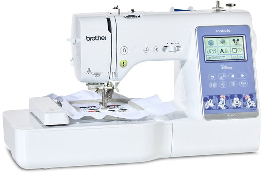 Brother Innov-is M380D: frontal view of the sewing and embroidery machine with embroidery hoop loaded on work area.