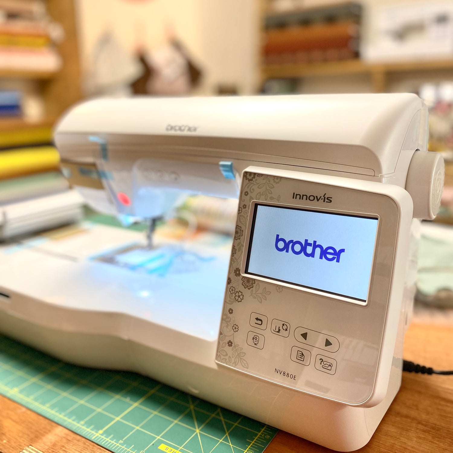 A close up image of the screen of the Brother innovis 880e embroidery machine showing the Brother branding