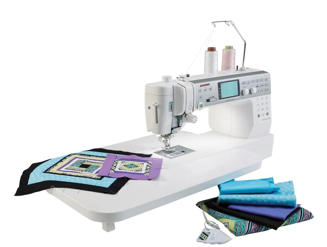 Janome Memory Craft 6700P sewing machine with extension table, showcasing the expansive work area and built-in thread stand, with vibrant quilting fabric ready for stitching.