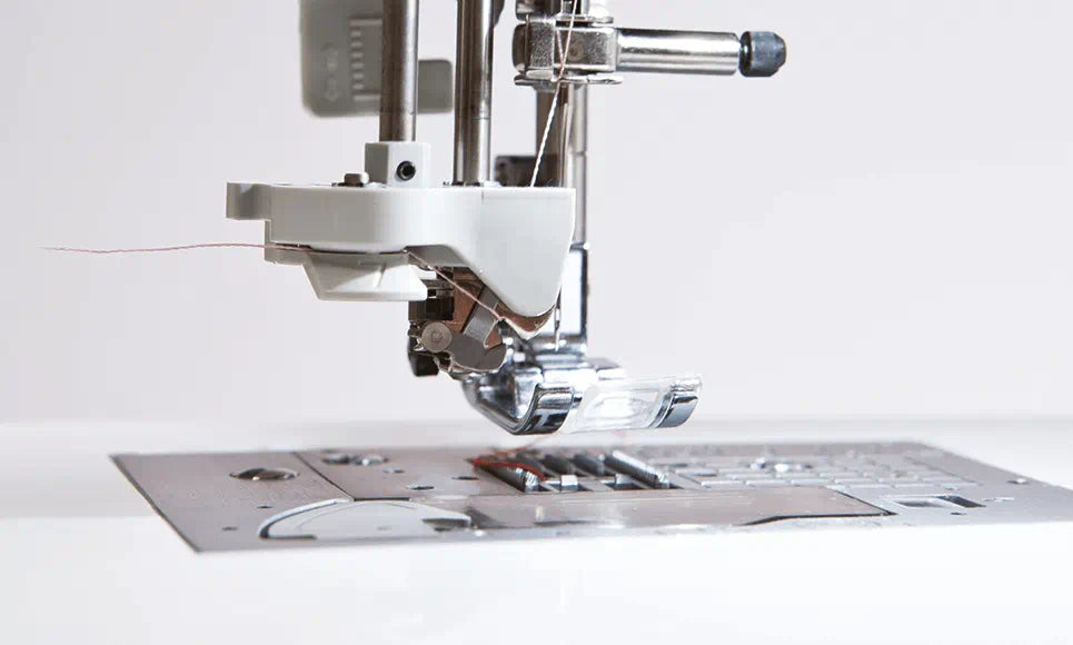 Alt description: "Detailed view of the Brother Innov-is NV1800Q's needle area showcasing the advanced needle threading system and the clear presser foot for precision sewing.
